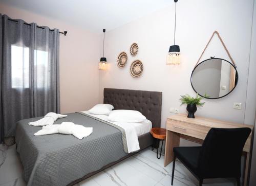 a bedroom with a bed and a desk and a mirror at GreKa apartments in Kalives Poligirou