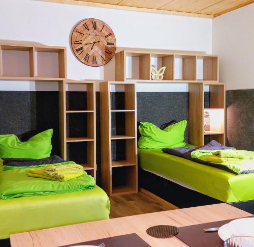 a room with two bunk beds and a clock on the wall at APARTMENTHAUS "AM KORNFELD" - 10 Gästewohnungen mit 1-3 Schlafzimmern, 40 Betten, Raucherbalkon, Reinigungs- & Wäscheservice, Grillgarten, Parkplatz in Lünen