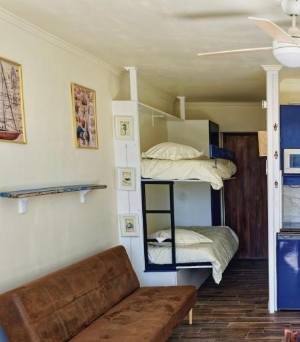 a living room with two bunk beds and a couch at Vacances au port in Saint-Cyprien-Plage