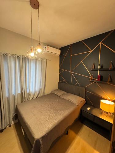 a small bedroom with a bed and a window at Triplex Aconchego in Itapoa