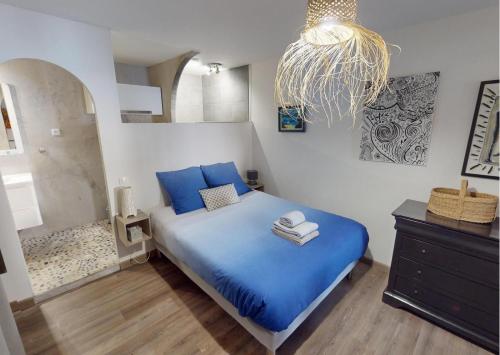 a bedroom with a blue bed and a chandelier at Sunset lodge in Bouzigues
