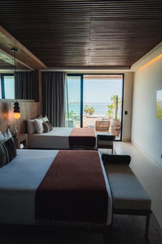 a hotel room with two beds and a large window at Republica Pagana - Only Adults in La Paz