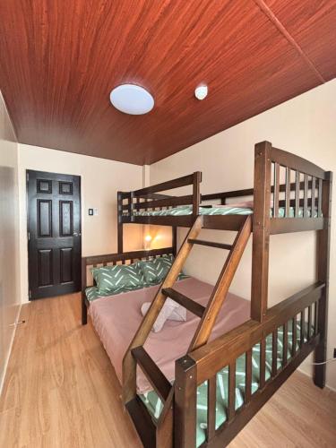 two bunk beds in a room with a wooden ceiling at Casa Selenó in Batangas City