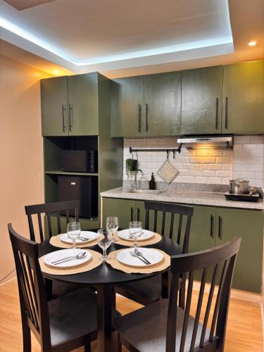 a dining room table with four chairs and a kitchen at Casa Selenó in Batangas City