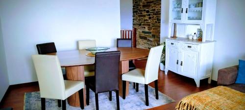 a kitchen and dining room with a table and chairs at Casa da Muralha in Vila Nova de Foz Coa