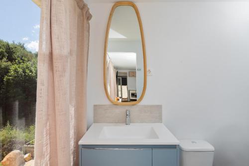 a bathroom with a sink and a mirror at Elysian by the sea in Nisaki
