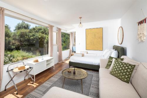 a living room with a couch and a bed at Elysian by the sea in Nisaki