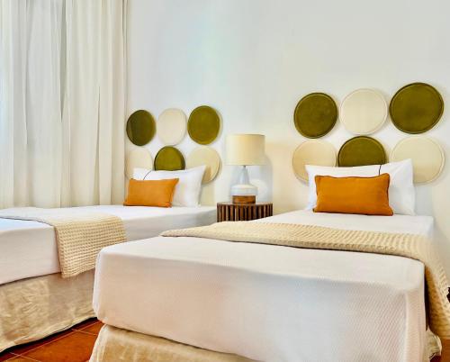 two beds in a room with white and green at Canaryislandshost l Bruma in Famara