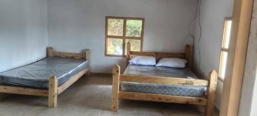 two beds in a room with a window at La Casa de Blue in Guarne