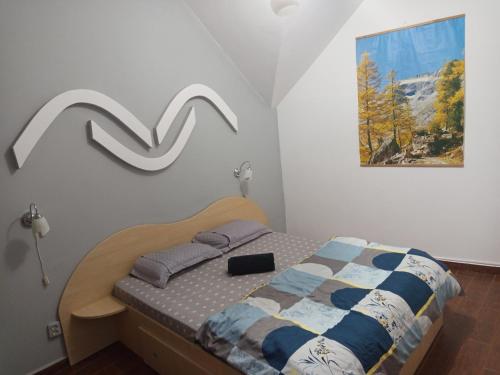 ein Schlafzimmer mit einem Bett und einem Bild an der Wand in der Unterkunft LaCoco in Buşteni
