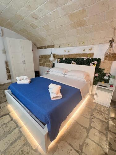 a bedroom with a large bed with a blue blanket at Il Cuore di San Cipriano in Mesagne