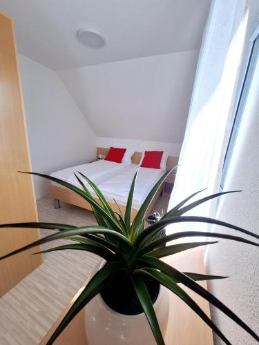 a bedroom with a bed and a potted plant at Špirala place - near city center, free parking in Bled