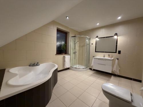 a bathroom with a tub and a shower and a sink at Klakierówka in Piechowice