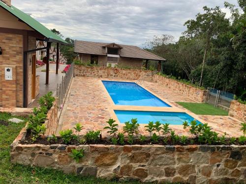a swimming pool in front of a house at Condominio Entre Bosques Cabaña 9 in Piedecuesta