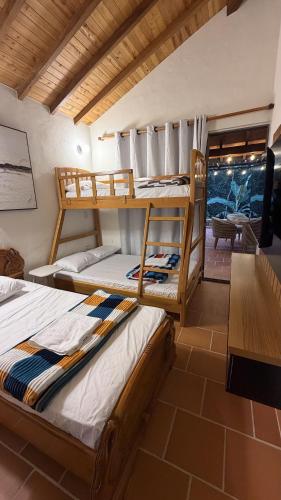 two bunk beds in a room with a table at Condominio Entre Bosques Cabaña 9 in Piedecuesta