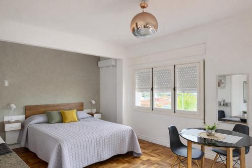 a bedroom with a bed and a table with chairs at Ana Rent II Departamento Moderno ,equipado en San Isidro cerca de Tigre River y Tecnopolis in Boulogne