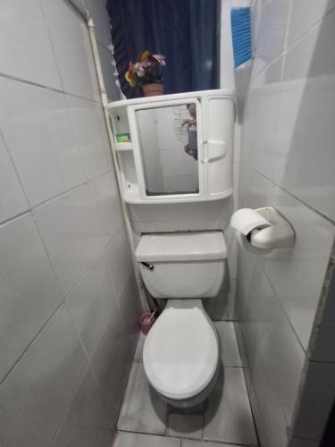 a small bathroom with a toilet with a mirror at Backpacker's ROOF in San Salvador