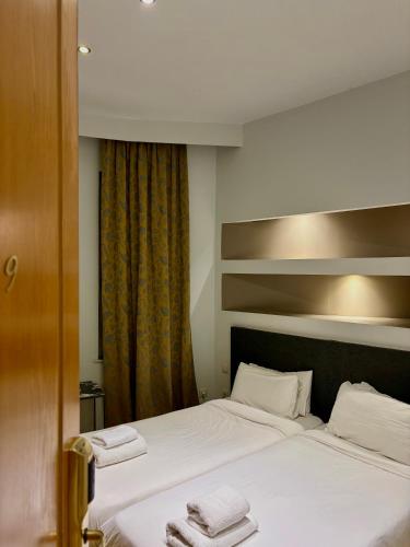 a bedroom with two beds with towels on them at Art Hotel Athens in Athens
