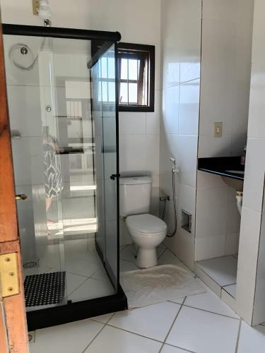 a bathroom with a toilet and a glass shower at Recanto Seu sossego ! in Maricá