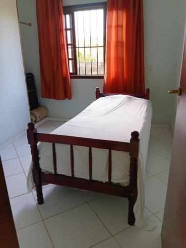 a small bed in a room with a window at Recanto Seu sossego ! in Maricá
