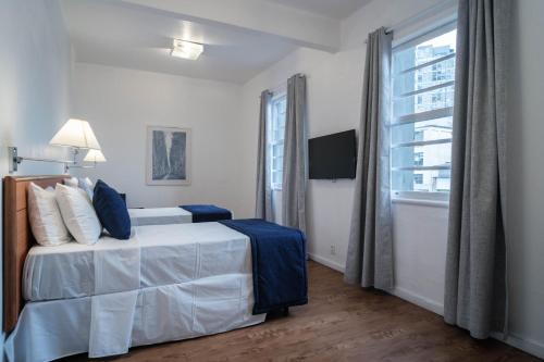 a bedroom with a bed and a large window at Hotel Normandie - by Easy Hotéis in São Paulo