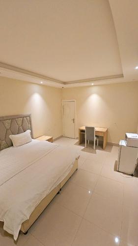 a bedroom with a large bed and a desk at استديو داخل بناية حي النرجس in Riyadh