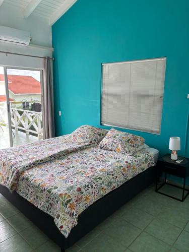 a bedroom with a bed and a blue wall at Blue Lagoon Apartment in Lagun