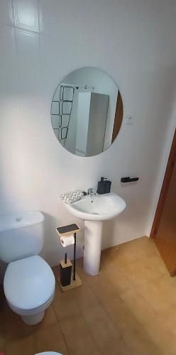a bathroom with a toilet and a sink and a mirror at Casa Corzo in María
