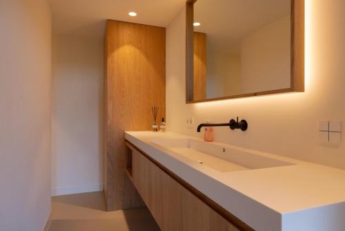a bathroom with a large white sink and a mirror at Guesthouse 'Elements' with panoramic views in Bergen