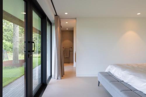 a bedroom with a bed and a sliding glass door at Guesthouse 'Elements' with panoramic views in Bergen
