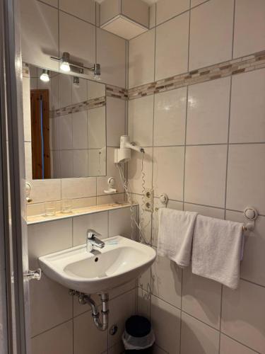 a bathroom with a sink and a mirror and towels at Hotel Maien in Todtmoos in Todtmoos