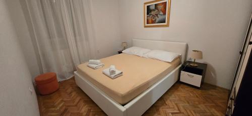 a small bedroom with a bed with two towels on it at Apartments Buljan in Kožino