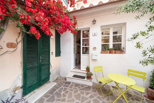 a table and chairs in front of a house with flowers at Villa Il Guardingo in Rio nellʼElba