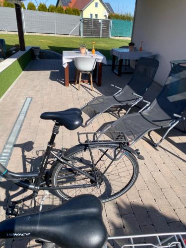 two chairs and a bike parked on a patio at Bagoly in Fertőrákos