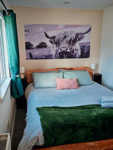 a bedroom with a bed with a painting of a bull at Half Pint in Tain