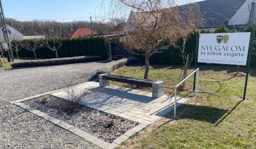 a sign and a bench next to a house at Ölyv in Fertőrákos