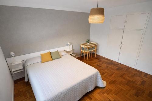 a bedroom with a white bed with two yellow pillows at Ana Rent lll Moderno departamento ,San Isidro punto medio Tigre River y Tecnopolis in Boulogne