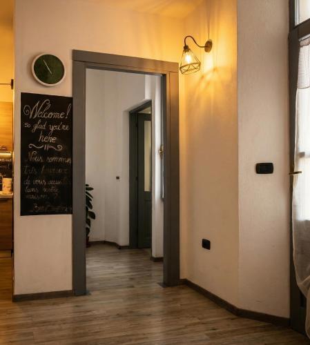 a hallway with a door and a chalkboard on the wall at Casa Tziu Predu - Centro Nuoro - B&Brothers in Nuoro