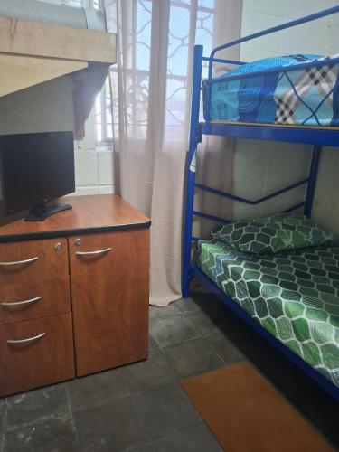 a bedroom with a bunk bed and a television at Backpacker's ROOF in San Salvador