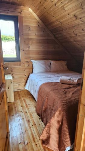 a bedroom with a bed in a wooden cabin at Memórias da Serra - Chalé Serra da Estrela Penhas da Saude in Penhas da Saúde