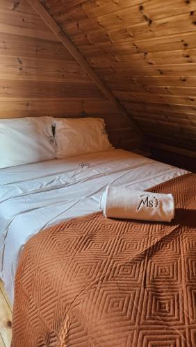 a bed in a room with a wooden ceiling at Memórias da Serra - Chalé Serra da Estrela Penhas da Saude in Penhas da Saúde