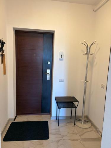 a wooden door in a room with a table and a lamp at Fantastic Cozy Studio in Sînpetru