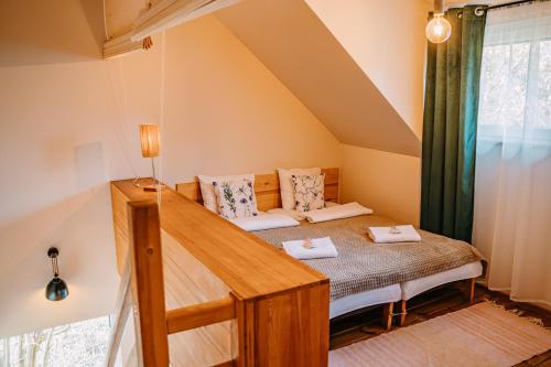 a bedroom with a bed in a attic at tuŻur domki nad potokiem in Osie