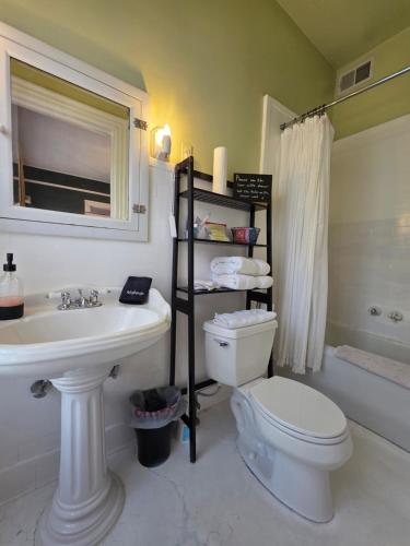 a bathroom with a white toilet and a sink at The Kings Throne Inn and Guest House in Toledo