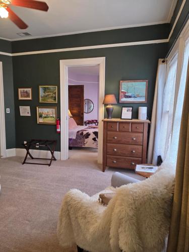 a room with a bedroom with a bed and a dresser at The Kings Throne Inn and Guest House in Toledo