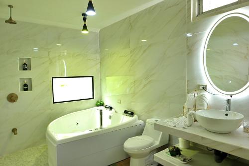 a bathroom with a tub and a sink and a toilet at Volcano Garden Suite with Hottub in Palma