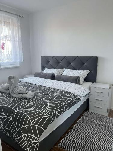 a bedroom with a bed with a teddy bear on it at ESEM stan na dan in Modriča