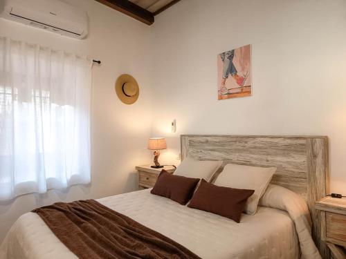 a bedroom with a large bed with two pillows at La Casita de Ale Casa Rural cerca Puy du Fou in Polán
