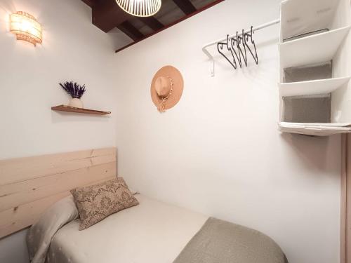 a white room with a bed and a shelf at La Casita de Ale Casa Rural cerca Puy du Fou in Polán