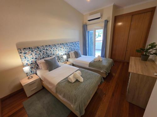 a bedroom with two beds with towels on them at Penthouse Quinta Village Garajau in Caniço